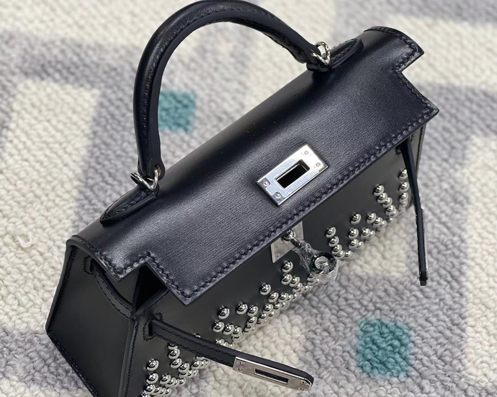 Mini bolso de piel con tachuelas de paladio
