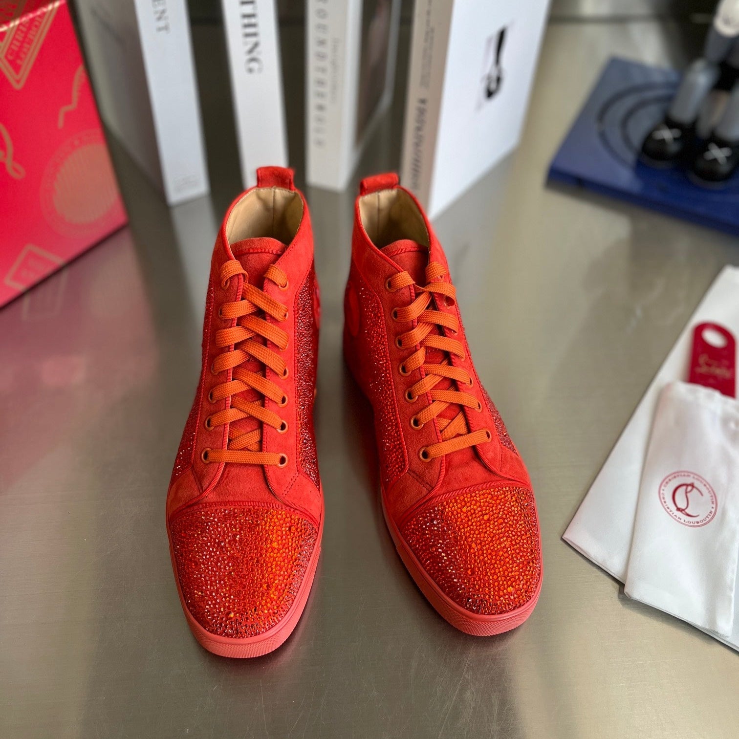 Botas altas naranjas con letras y tachuelas de diamantes
